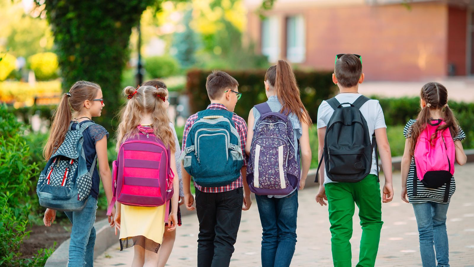kids walking with backs turned and backpacks on